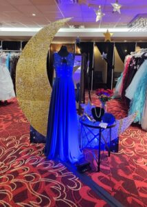 A blue dress with a sparkly gold moon behind it.